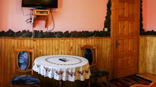 a room with a table and a tv on a wall at Guest house Dvir Pysanka in Kosiv