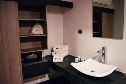 La salle de bains est pourvue d'un lavabo et d'un comptoir avec des serviettes. dans l'établissement Hotel Ht Ole, à Tijuana