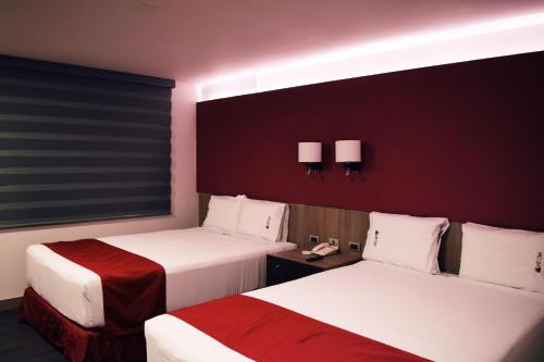 Cette chambre comprend deux lits et un téléphone. dans l'établissement Hotel Ht Ole, à Tijuana