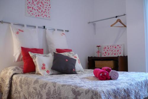 1 dormitorio con 1 cama con almohadas rojas y blancas en Habitación La Luz, en Granada