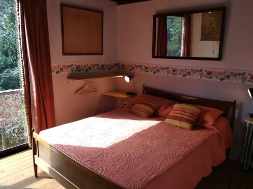 a bedroom with a bed and a mirror and a window at Posada IRSIS in La Pedrera