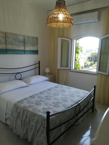 a bedroom with a large bed and a chandelier at Casa Malo' in Ischia