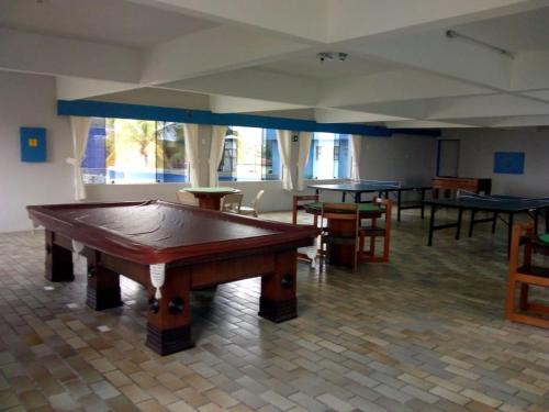 a pool table in a room with several tables at 27 Praia Hotel - Frente Mar in Bertioga