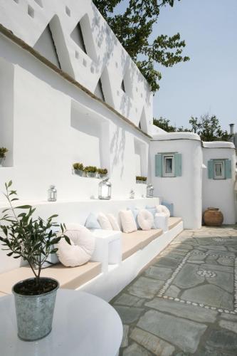 een wit huis met witte muren en een patio bij Studios Eleni II in Tinos Town