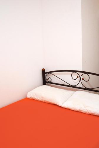 a bedroom with a bed with an orange and white at Hostel Train Station in Kyiv