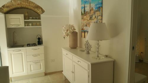 a kitchen with a table with a lamp on it at Suite Pitagora in Bernalda