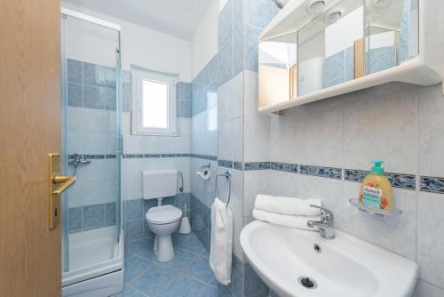 a bathroom with a sink and a toilet and a shower at Villa Marivel in Privlaka