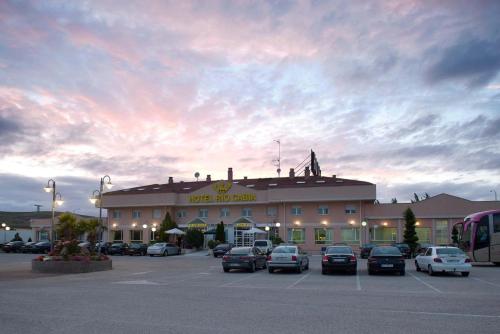 a large building with cars parked in a parking lot at Hotel Río Cabia in Cabia