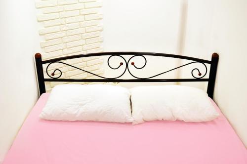 a bed with a black frame and two white pillows at Hostel Train Station in Kyiv