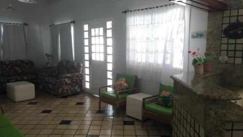 a living room with a couch and chairs and windows at Casa em Escarpas do Lago in Capitólio