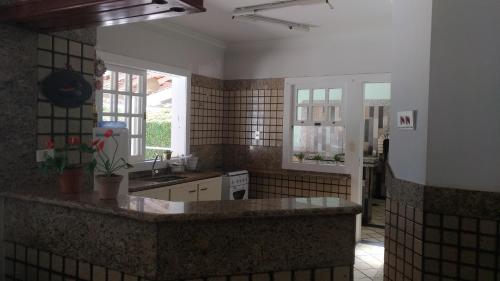 uma cozinha com um lavatório e uma bancada em Casa em Escarpas do Lago em Capitólio