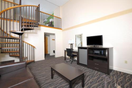 a living room with a couch and a tv and a staircase at Country Cascades Waterpark Resort in Pigeon Forge
