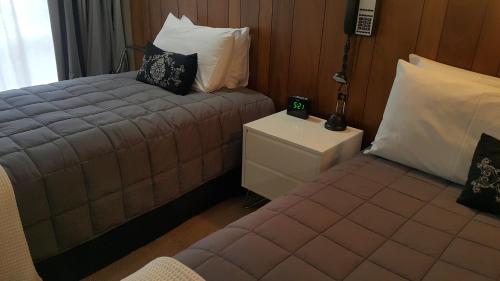 a small bedroom with a bed and a night stand at 299 On Devon West in New Plymouth