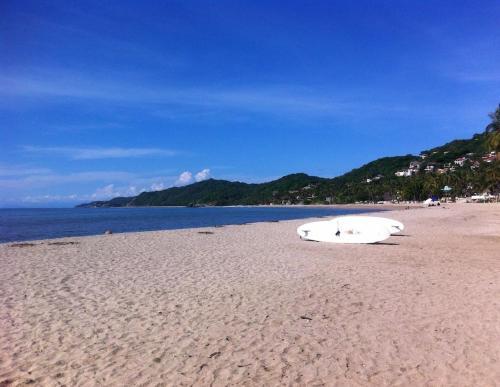 a surfboard and a surfboard laying on a beach at Junto al Rio Bungalows & Suites in Sayulita