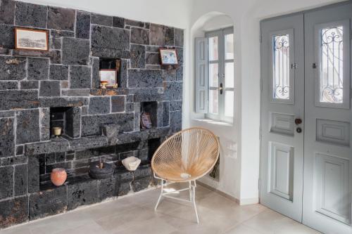 a chair in front of a brick wall at Sweet nectar villa at Pyrgos with heated jacuzzi in Pyrgos