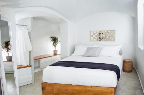 a white bedroom with a large bed and a mirror at Sweet nectar villa at Pyrgos with heated jacuzzi in Pyrgos