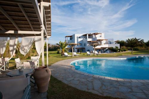 a resort with a swimming pool and a building at Ammos Naxos Exclusive Apartments & Studios in Naxos Chora