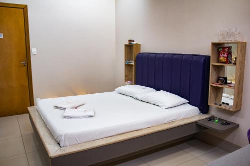 a bed with a blue headboard in a room at Rodotel Venus (Adults Only) in Jataí