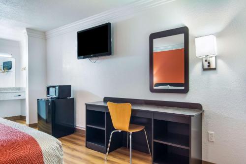 a hotel room with a desk and a mirror at Motel 6-Marshall, TX in Marshall