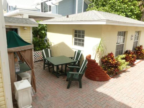 eine Terrasse mit einem Tisch und Stühlen sowie ein Haus in der Unterkunft Sand Glo Villas in Clearwater Beach