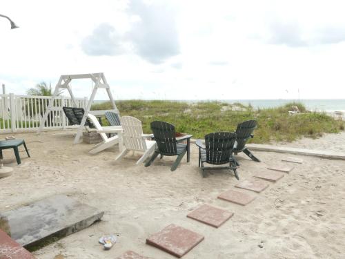 a group of chairs and a table on the beach at Sand Glo Villas in Clearwater Beach
