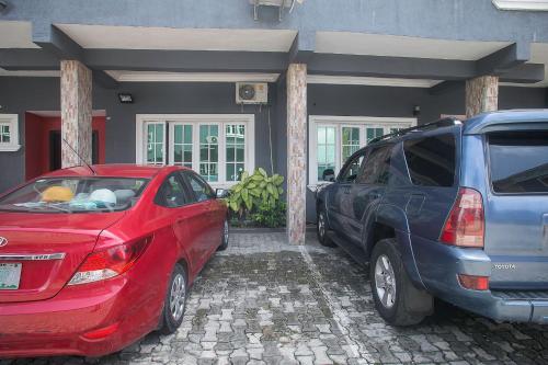 two cars parked in front of a house at Large 1 Bedroom Apartment On The Gound Floor, Lekki in Lekki