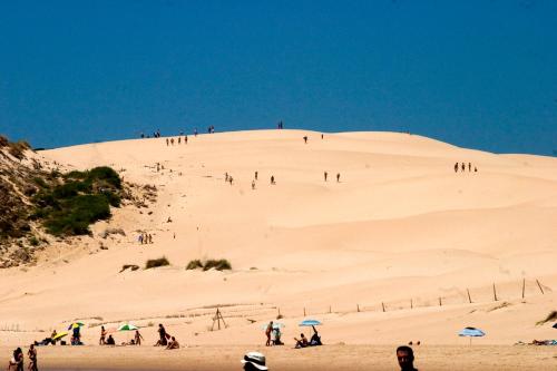 een groep mensen bovenop een zandheuvel bij La Era in Tarifa
