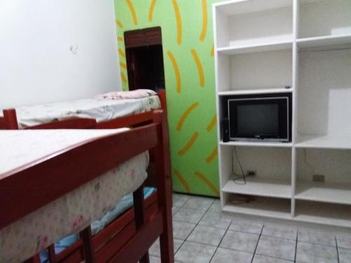 a bedroom with two bunk beds and a tv at Pousada Santa Helena in Juazeiro do Norte