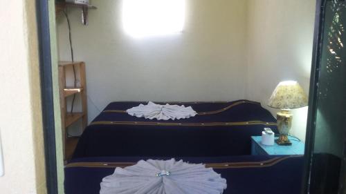 a bedroom with two beds and a table with a lamp at Hospedaje Eli Panajachel in Panajachel