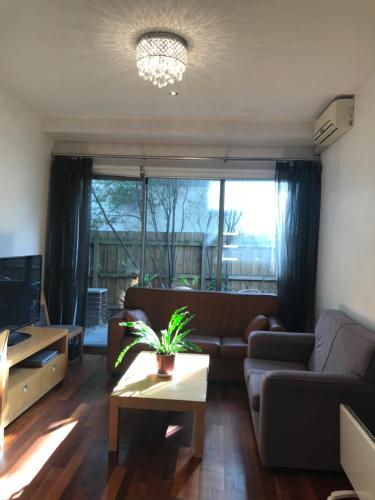 a living room with a couch and a table at Beachside Apartments Bonbeach in Bonbeach