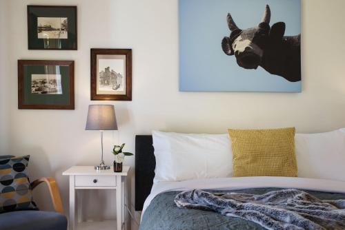 a bedroom with a bed and a picture of a cow on the wall at Old Chilli Daylesford in Daylesford