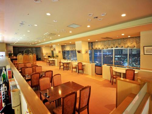 a restaurant with tables and chairs and a bar at Nisshokan Shinkan Baishokaku in Nagasaki