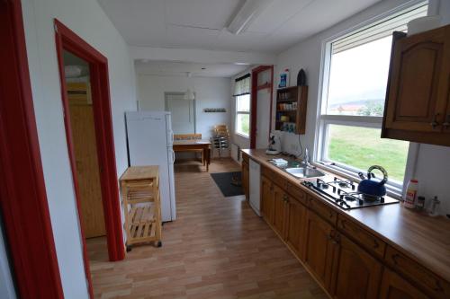 cocina con fregadero y nevera en Bragdavellir Holiday Home, en Djúpivogur