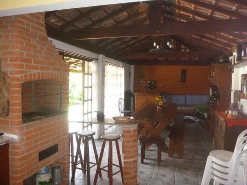 a kitchen with a brick fireplace and a table and chairs at Recanto de Oryon in São Pedro
