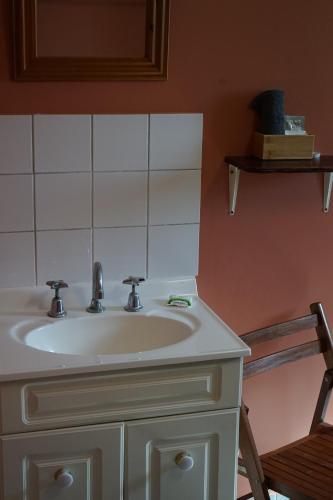 a white sink in a bathroom with a mirror at Point Stuart Wilderness Lodge in Point Stuart
