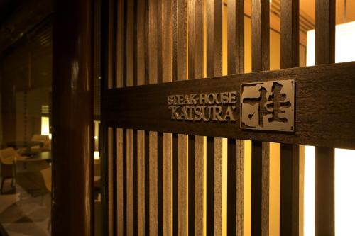 a sign on the side of a wooden fence at Takanawa Hanakohro - in Grand Prince Hotel Takanawa in Tokyo