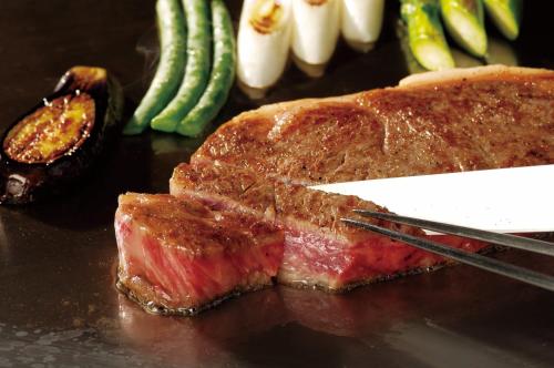 a piece of meat with a knife and some vegetables at Takanawa Hanakohro - in Grand Prince Hotel Takanawa in Tokyo