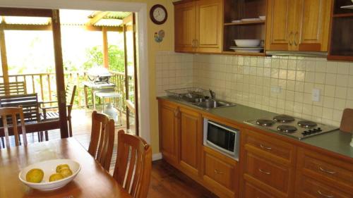 a kitchen with a table with a bowl of fruit on it at The Blue House Yungaburra in Yungaburra