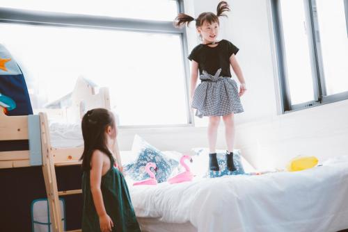 a little girl standing on top of a bed at Meng Yun Ge Hotel in Jiaoxi