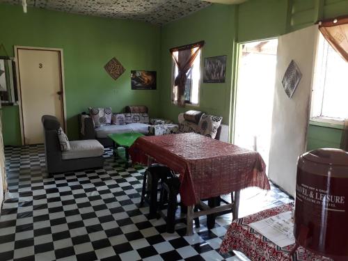 a living room with green walls and a checkered floor at Mulu D cave homestay in Mulu