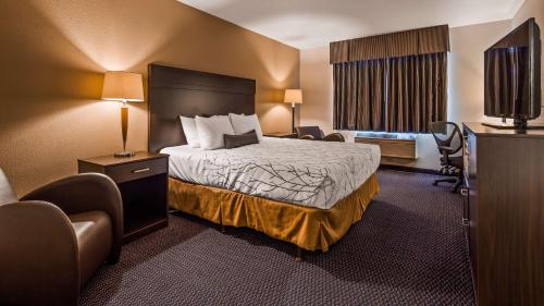 una habitación de hotel con una cama y un televisor en SureStay Plus Hotel by Best Western Post Falls, en Post Falls