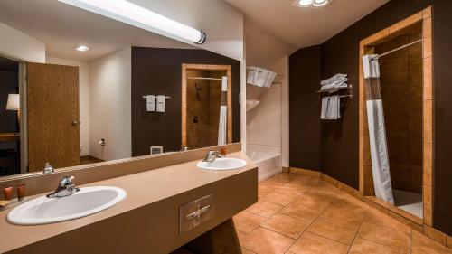 a bathroom with two sinks and a large mirror at SureStay Plus Hotel by Best Western Post Falls in Post Falls