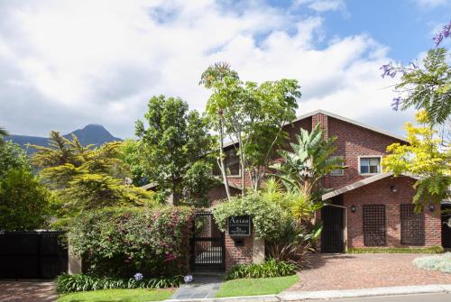 a brick house with trees and bushes at Aziza Guest House in George