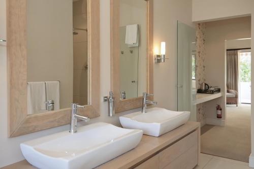 a bathroom with two sinks and a mirror at Aziza Guest House in George