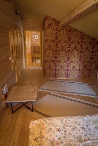 a room with two beds and a wall with wallpaper at Hargita Udvarhaz Zetevaralja in Sub Cetate