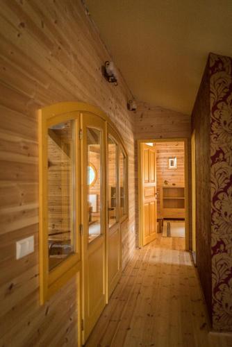 a hallway in a log cabin with wooden walls and wooden floors at Hargita Udvarhaz Zetevaralja in Sub Cetate