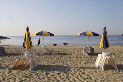 a group of chairs and umbrellas on a beach at Camping Village Cavallino in Cavallino-Treporti