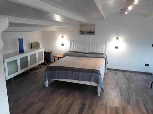 a bedroom with a large bed with a wooden floor at Via Pezza 100 in Ragusa