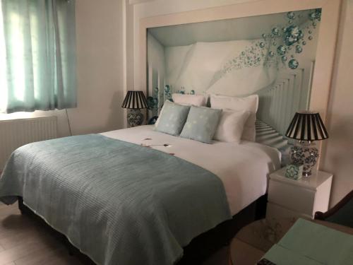 ロンドンにあるAffordable Lux and Cozy 1 bed flat in Chelseaのベッドルーム(白い大型ベッド、ランプ2つ付)