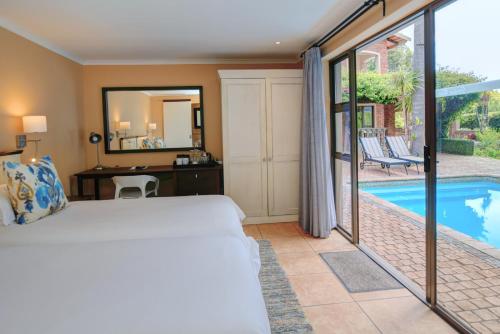 a bedroom with a bed and a swimming pool at Aziza Guest House in George